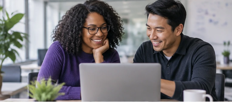 Two professionals collaborating over a laptop.